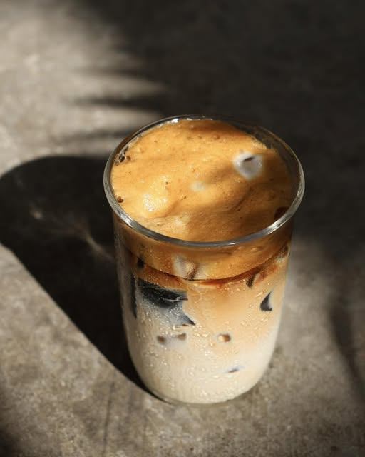 Iced coffee in a glass, lit by afternoon light