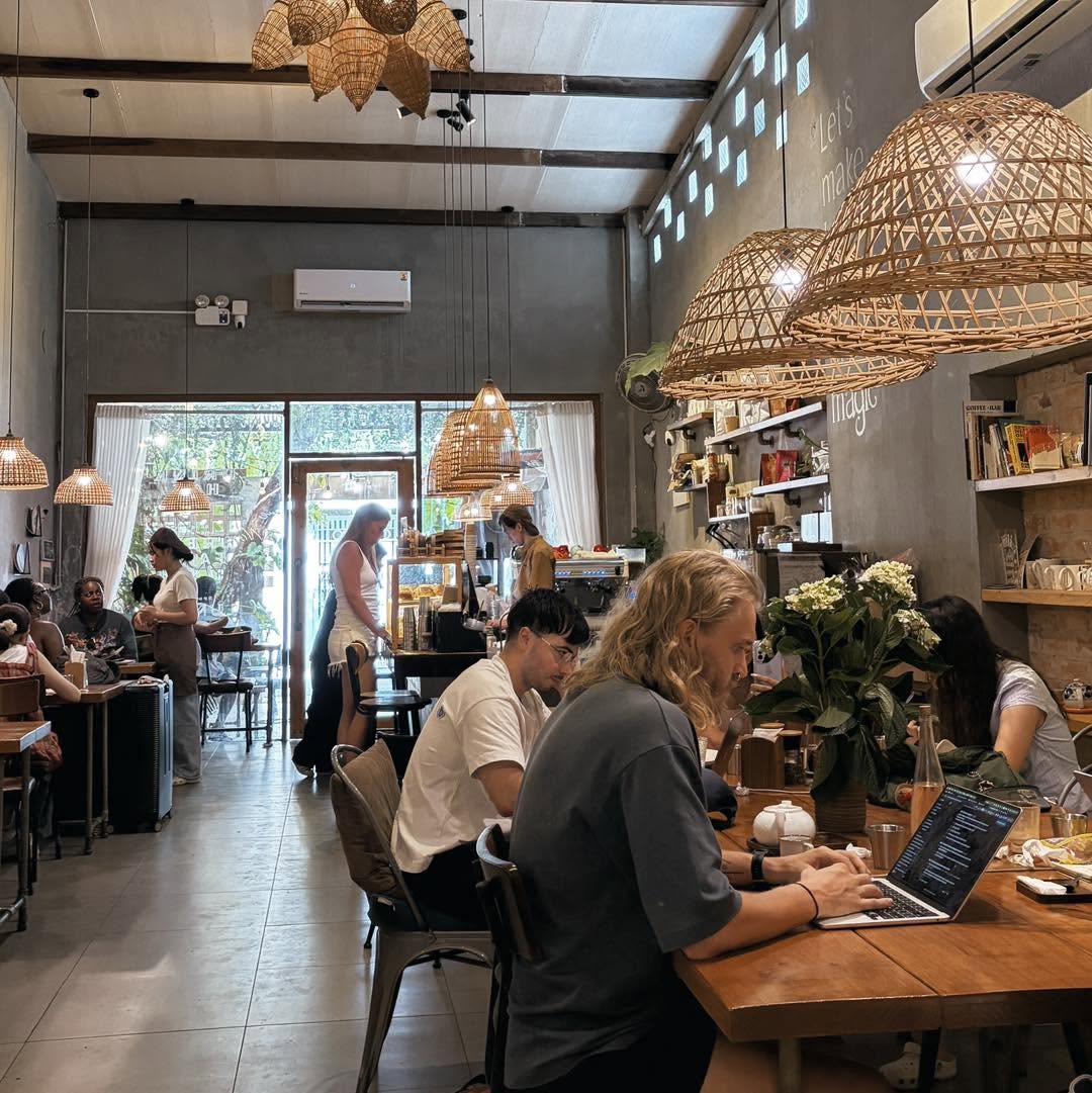Inside The Hideout Café — rattan pendant lights, high ceilings and long shared tables
